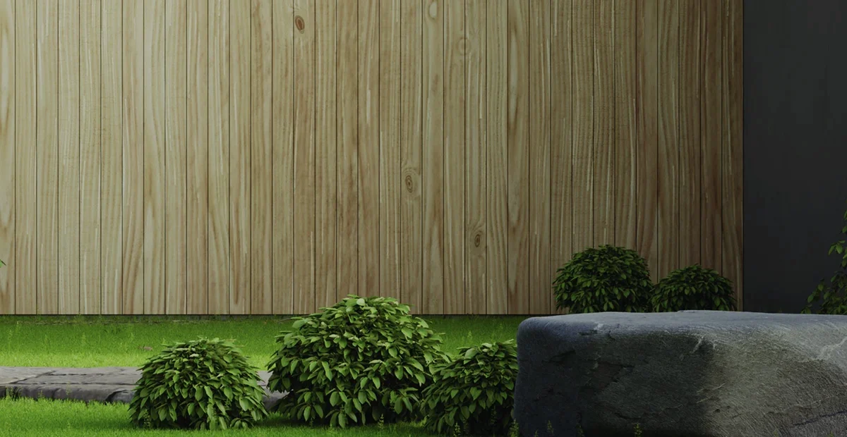 A courtyard with a timber screen wall, clipped shrubs and a natural stone boulder